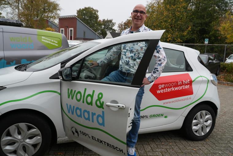 Man houdt de deur open van een elektrische deelauto.