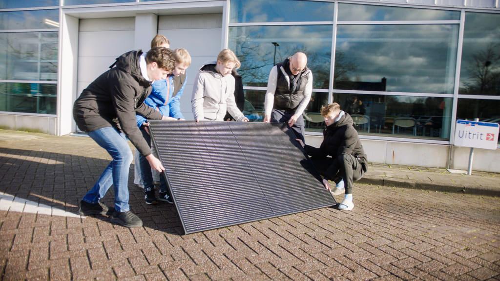 Studenten van het ROC Horizon College in Hoorn verplaatsen een zonnepaneel.