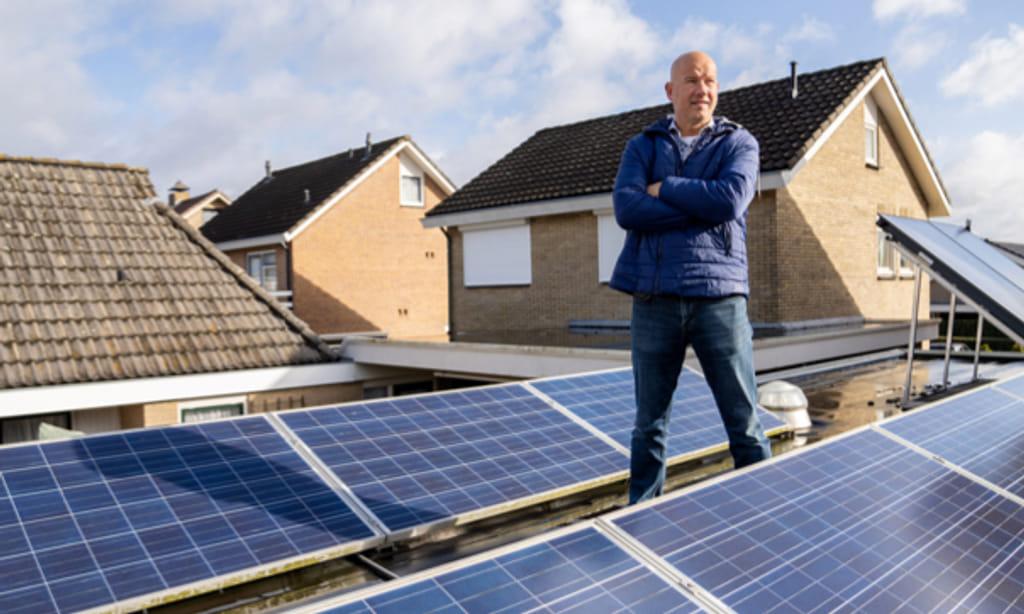Foto van Alex Nijland die op een dak vol zonnepanelen staat.