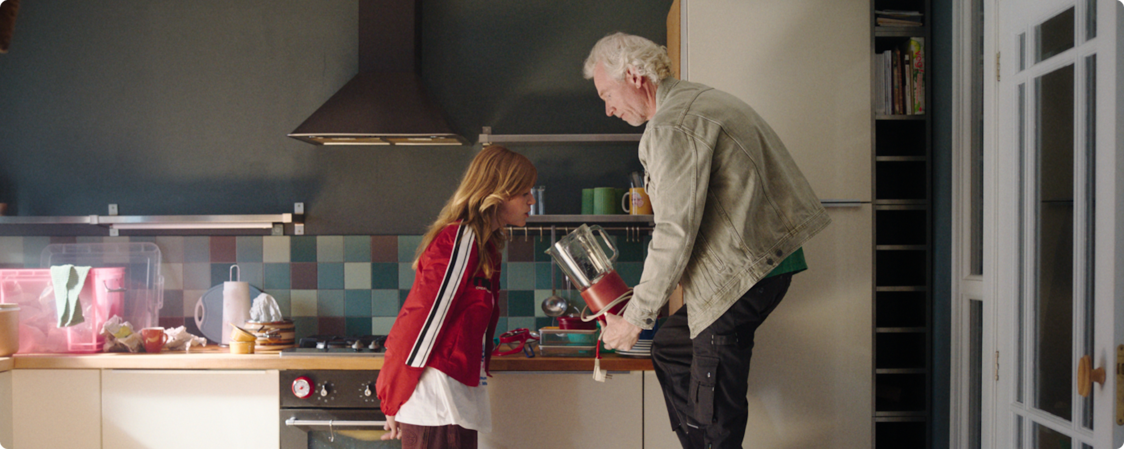 Ewout en zijn dochter Julia staan in de keuken spullen uit te zoeken. Ewout houdt een blender voor het gezicht van Julia.