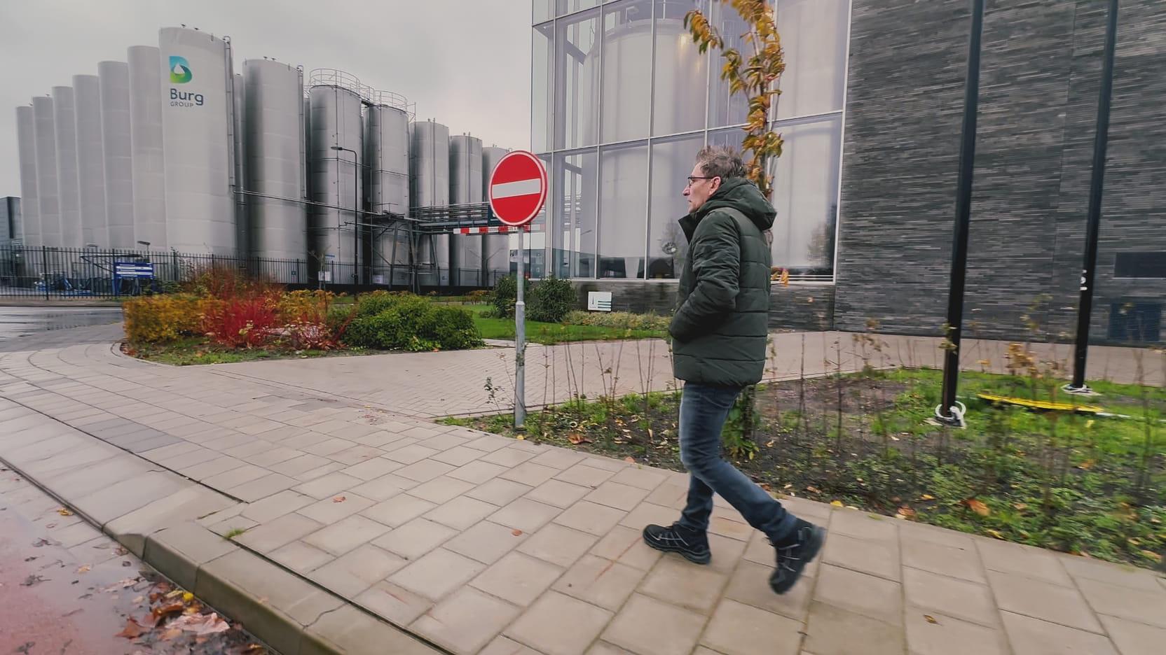 Man loopt op het terrein van de azijnfabriek.
