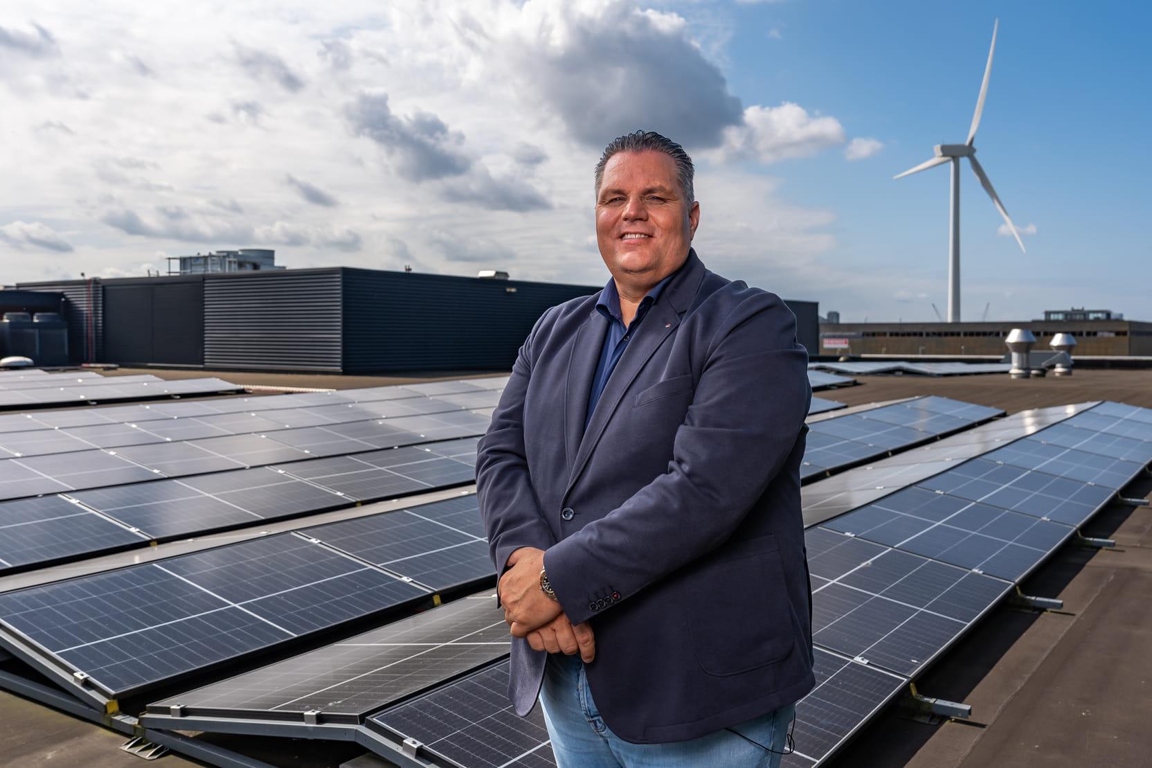 Foto van directeur Dennis de Borst op het dak van de FEBO-fabriek. Er liggen veel zonnepanelen.