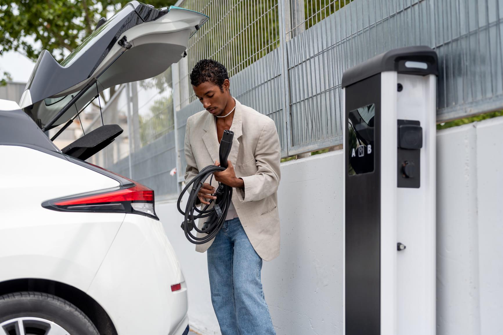 Man bergt laadkabel op in een elektrische auto.