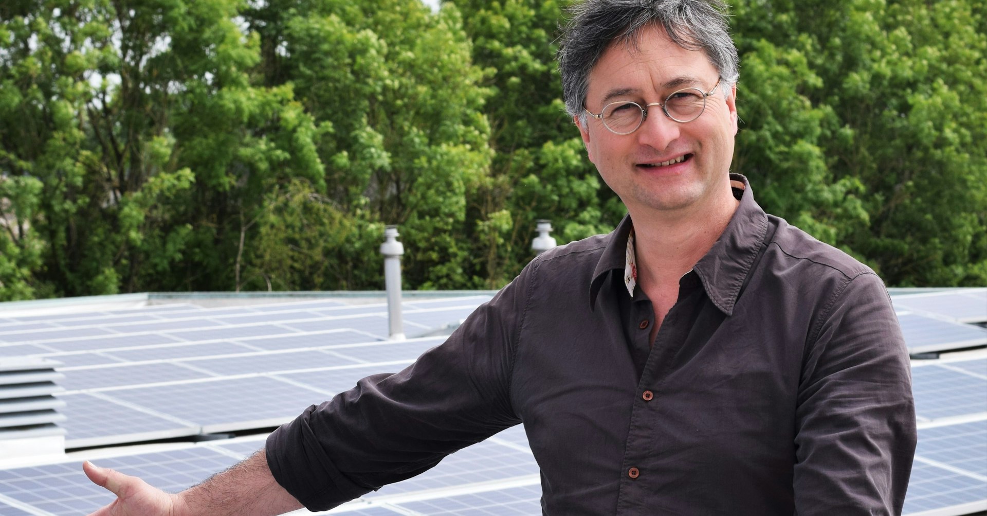 Mkb-ondernemer Michel Jansen staat voor een plek met veel zonnepanelen. In zijn linkerhand houdt hij het product vast: soeppotten van de Kleinstesoepfabriek.