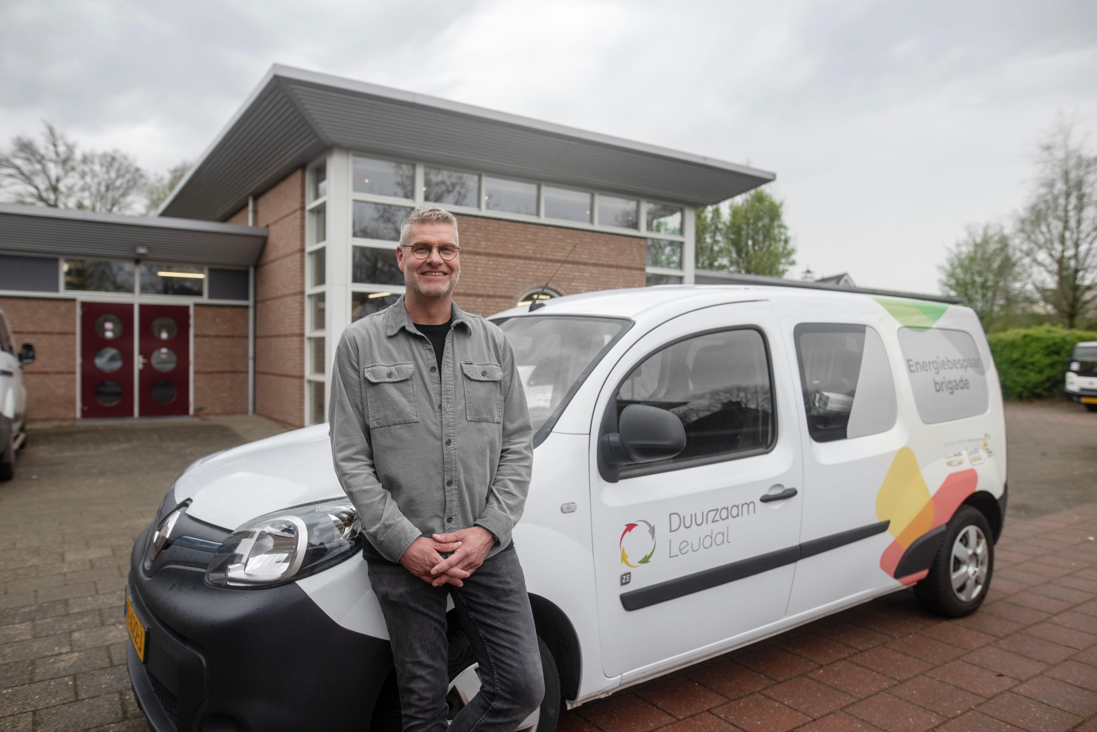 Foto van Wim Geelen van Duurzaam Leudal. Hij staat voor het witte busje waarmee hij naar mensen rijdt om energiebesparende maatregelen te nemen.