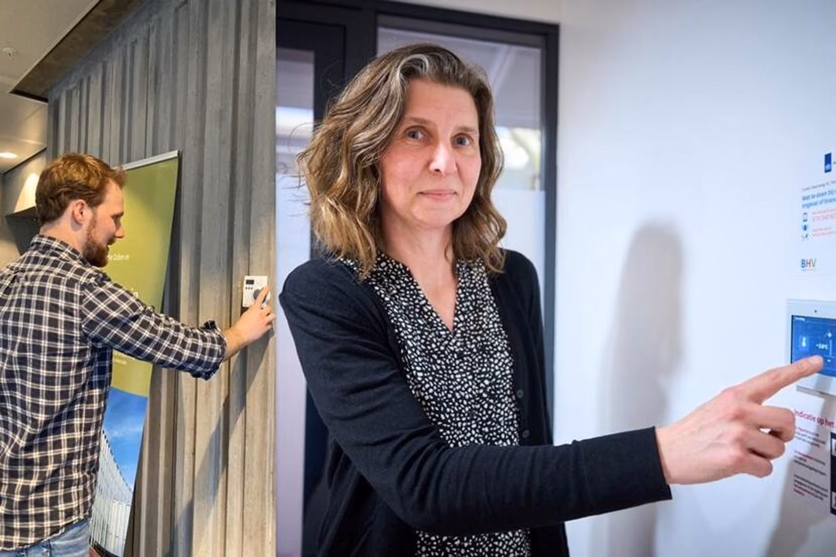 Een vrouw die werkt binnen de overheid, bedient een energiedisplay.