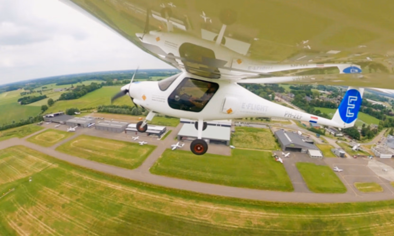 Foto van een vliegtuig van E-flight in de lucht. De foto is gemaakt vanaf de vleugel.