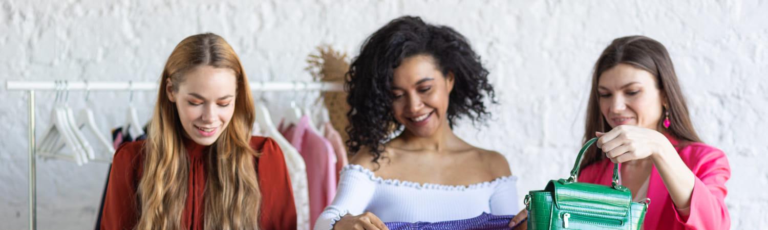 Drie vrouwen op een kledingruilfeestje.