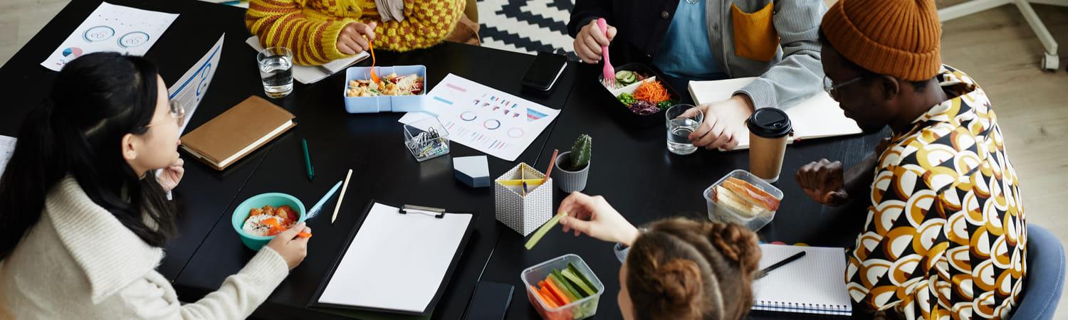 Collega's zitten te lunchen terwijl ze een project bespreken.