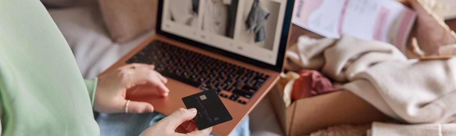 Vrouw houdt een creditcard vast om een online bestelling te plaatsen in een webshop.
