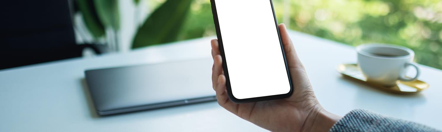Iemand houdt een telefoon vast en kijkt ogenschijnlijk naar het scherm.