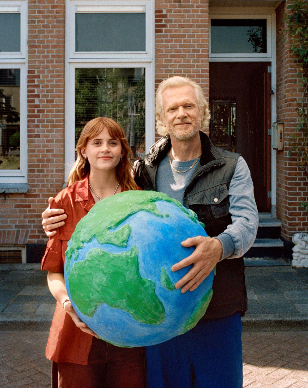 Vader en dochter houden samen een wereldbol vast.