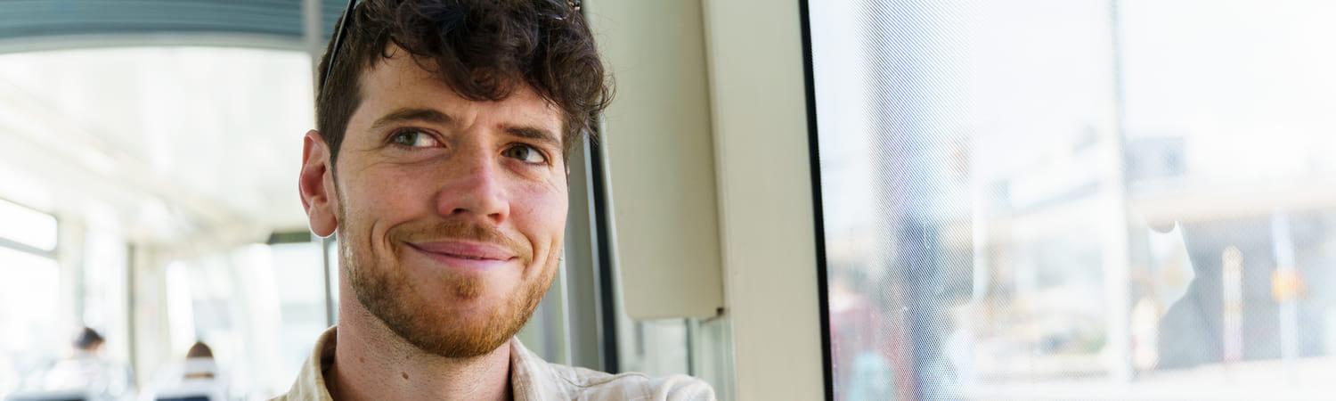 Man zit in een metro en kijkt op zijn telefoon.