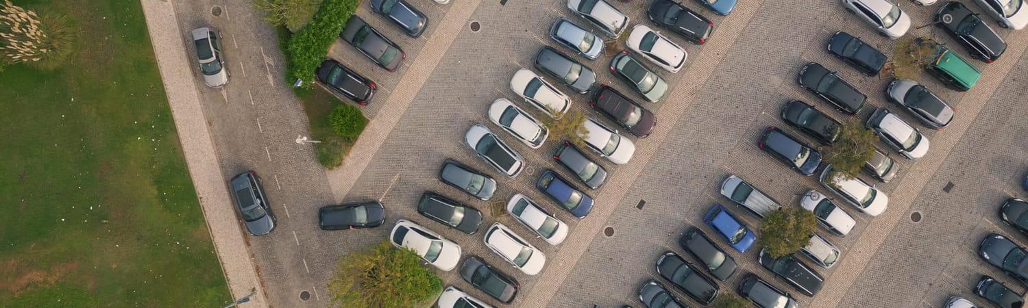 Een foto van bovenaf van een volle parkeerplaats.