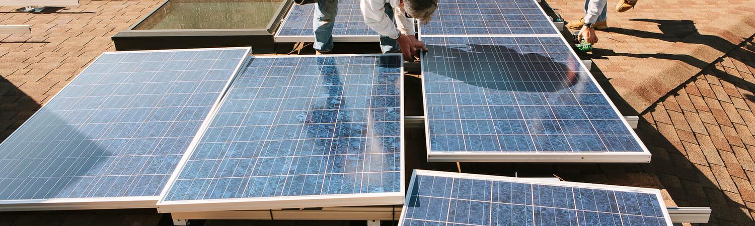 Twee mannen leggen zonnepanelen klaar om te installeren.