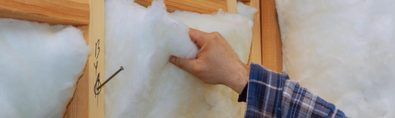 Handen die bezig zijn met het isoleren van een gebouw.