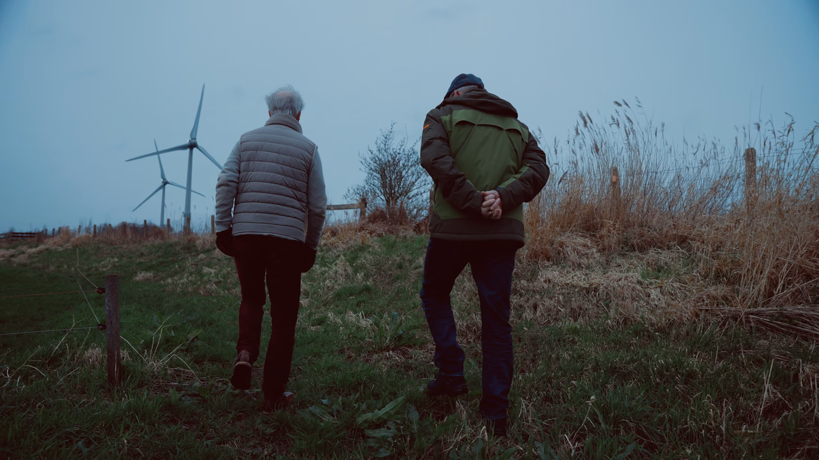 Rob Boerée en buurtbewoner wandelen naar de Watergeuzen-windmolens.