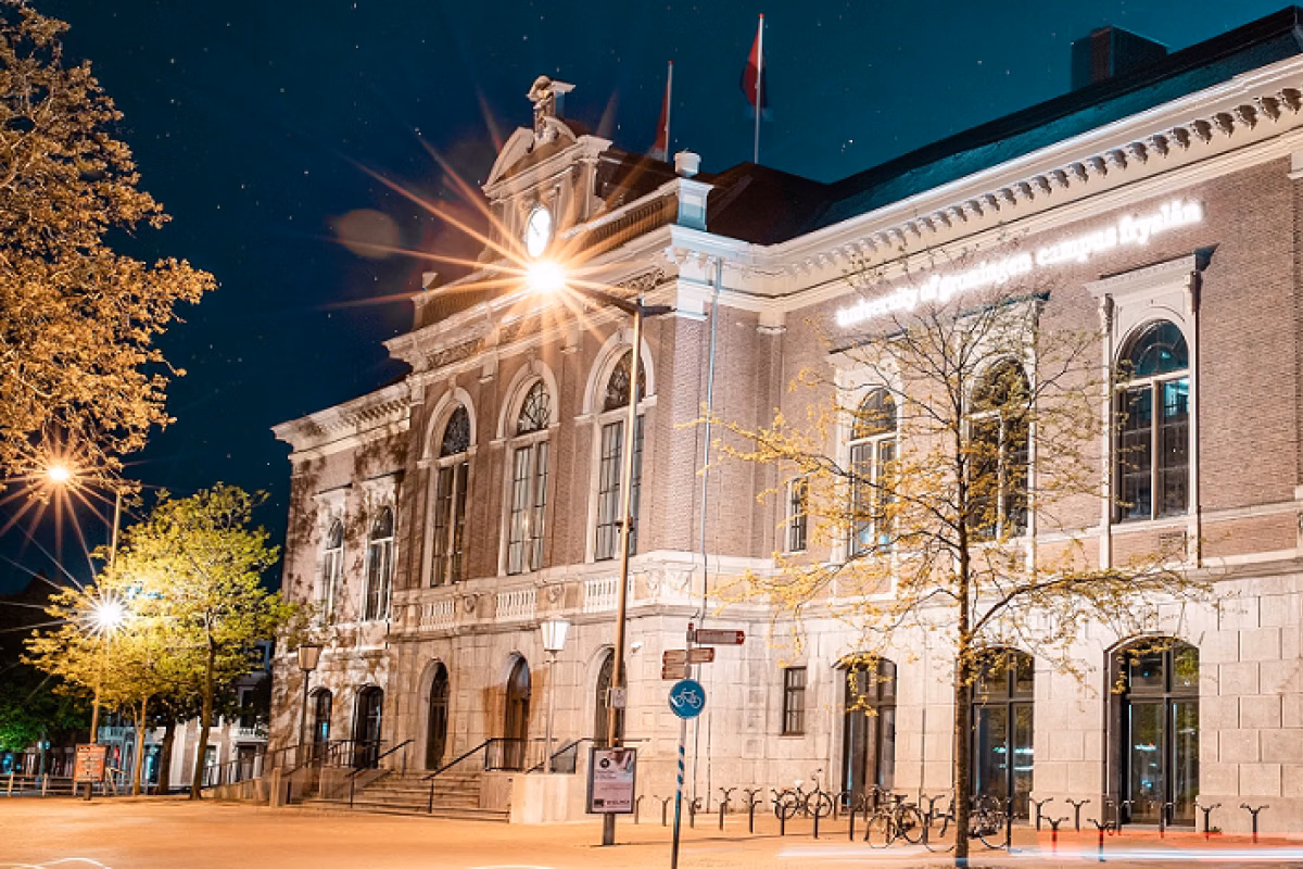 Foto van het onderwijsgebouw van de campus Fryslan in de avond.